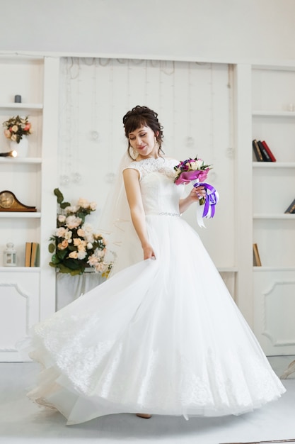 La novia con un hermoso vestido blanco se está preparando para la ceremonia de la boda. Mañana de la novia