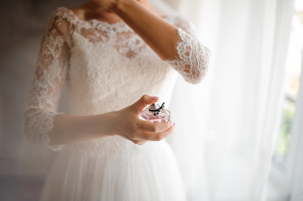 Novia en un hermoso vestido de novia blanco con perfume