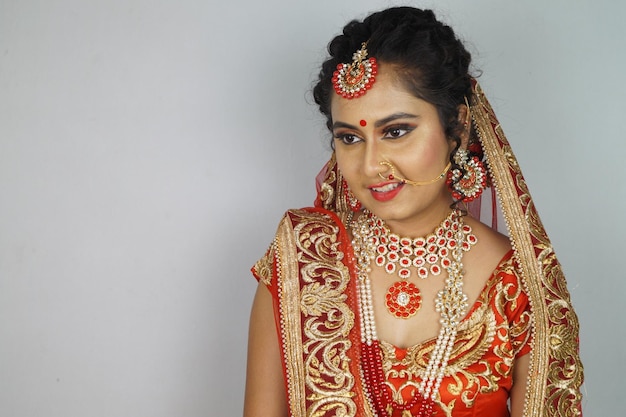 Novia india con un maquillaje brillante que lleva un lehenga aislado en un fondo blanco