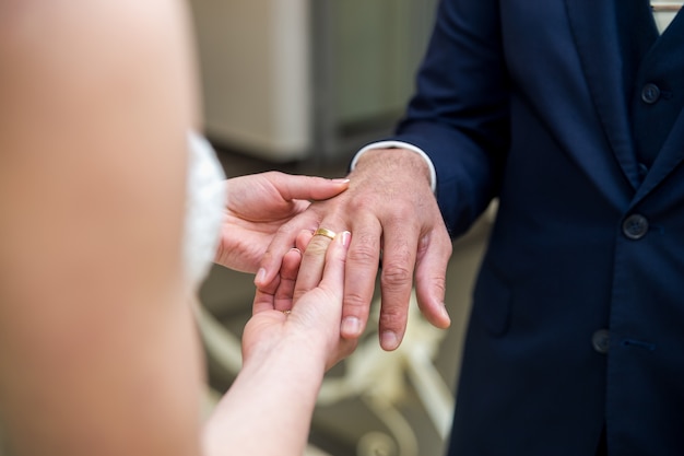 la novia lleva un anillo de bodas en el novio.