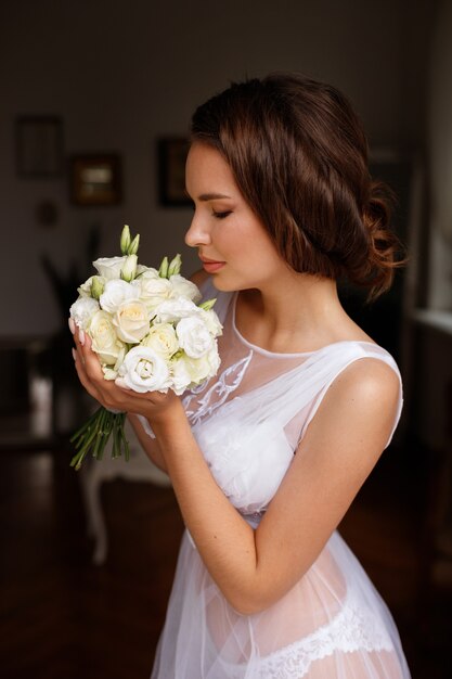 Novia por la mañana con un ramo de flores.