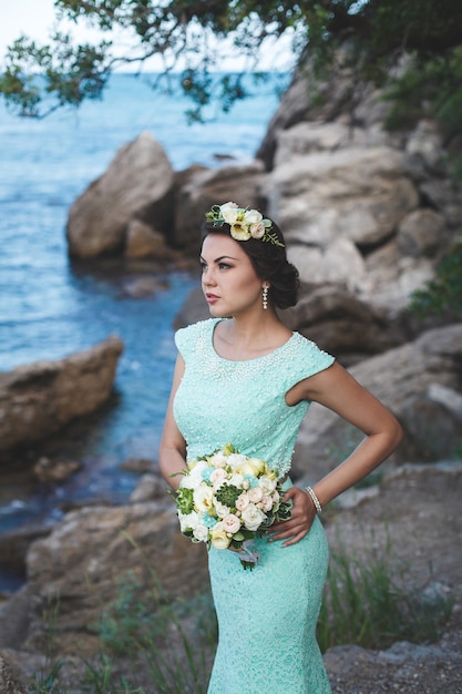 Novia en la naturaleza en las montañas cerca del agua