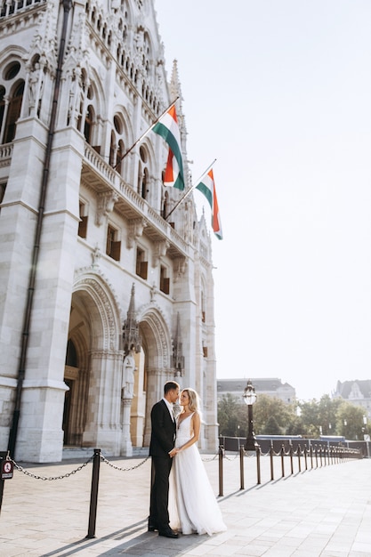 Novia y el novio abrazando en la calle del casco antiguo. Novios enamorados Vestido de diamantes de imitación de lujo.