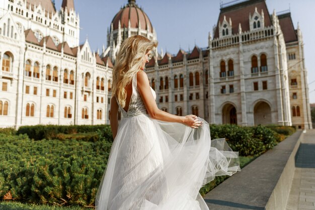 Novia y el novio abrazando en la calle del casco antiguo. Novios enamorados Vestido de diamantes de imitación de lujo.