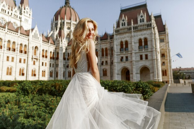 Novia y el novio abrazando en la calle del casco antiguo. Novios enamorados Vestido de diamantes de imitación de lujo.