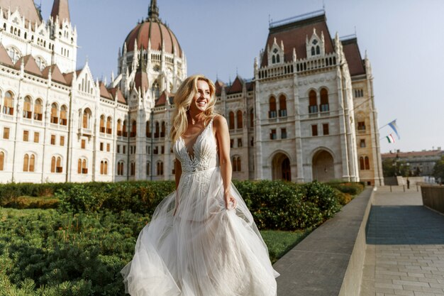 Novia y el novio abrazando en la calle del casco antiguo. Novios enamorados Vestido de diamantes de imitación de lujo.