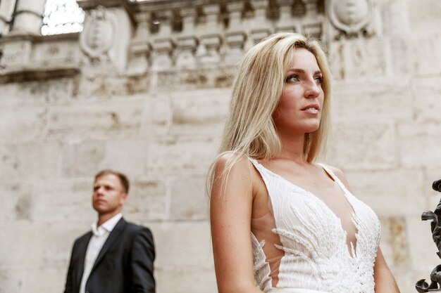 Novia y el novio abrazando en la calle del casco antiguo. Novios enamorados Vestido de diamantes de imitación de lujo.