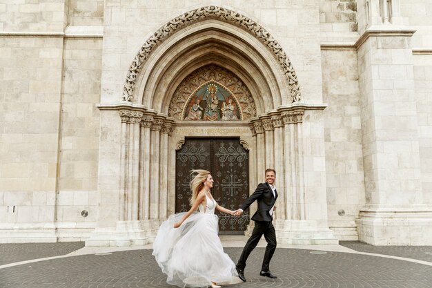 Foto novia y el novio abrazando en la calle del casco antiguo. novios enamorados vestido de diamantes de imitación de lujo.