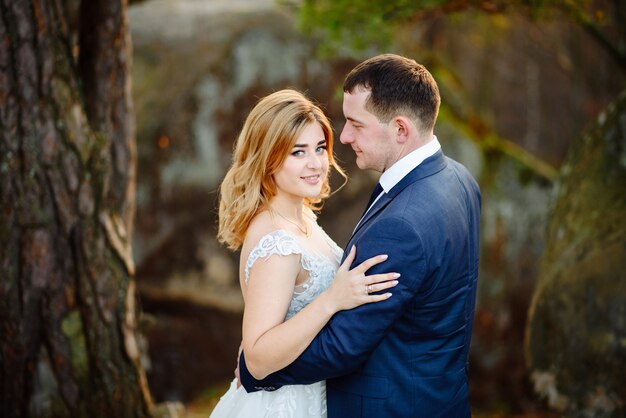 Novia y novio abrazando en la naturaleza