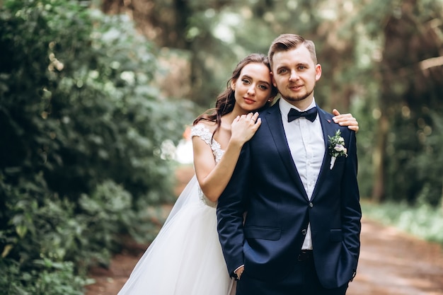 La novia y el novio abrazándose, besándose al aire libre el día de la boda, pareja joven, día de san valentín