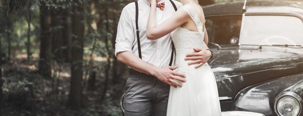 Novia y novio abrazándose en un bosque cerca del día de la boda de recién casados