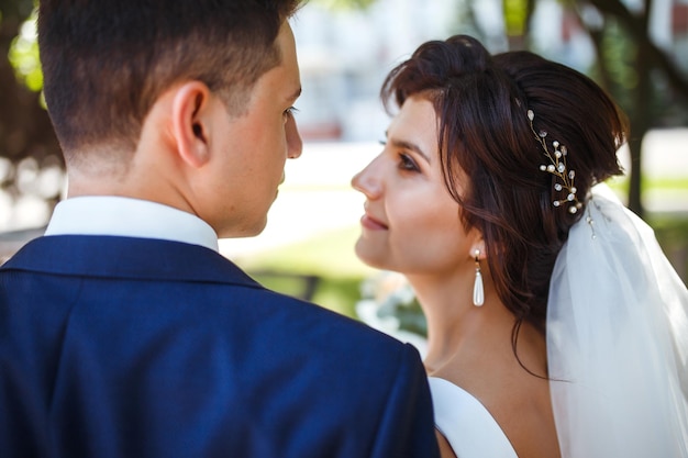 La novia y el novio caminan juntos en el parque Bonita novia y elegante novio Día de la boda Matrimonio