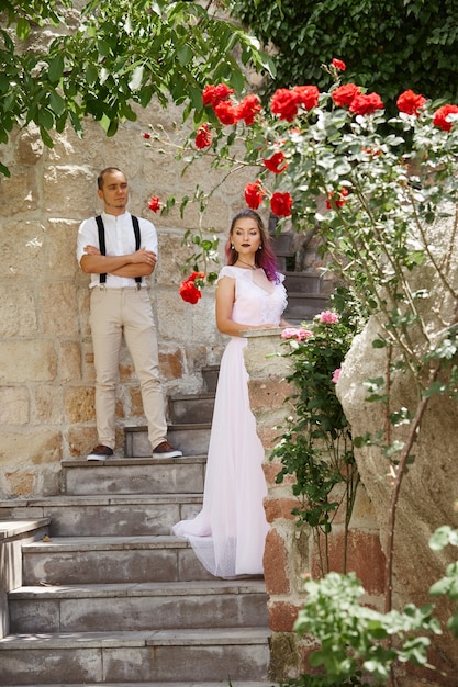 La novia y el novio caminando por las escaleras con rosas