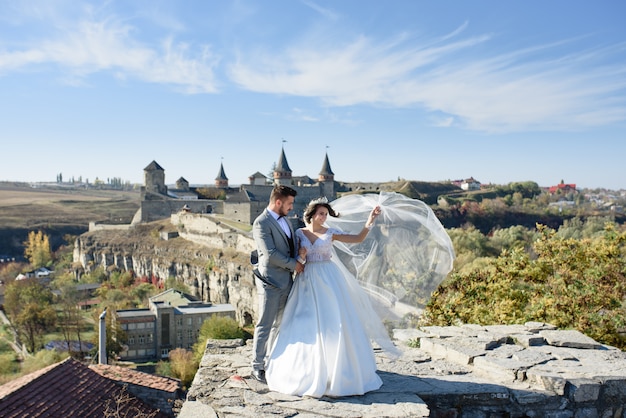 Novia y novio cerca de un viejo castillo