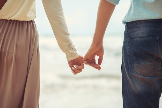 La novia y el novio cogidos de la mano de cerca en la playa. Vacaciones. Phuket. Tailandia