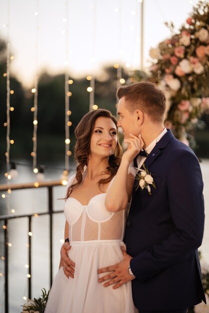 Novia y novio contra el telón de fondo de una puesta de sol amarilla