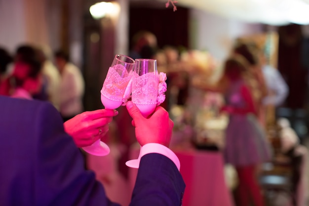 La novia y el novio con copas de champán tintinean