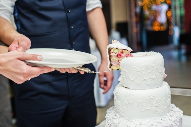 La novia y el novio cortan el tradicional pastel de bodas.