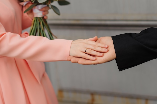 La novia y el novio se dan la mano en la puerta de la iglesia.