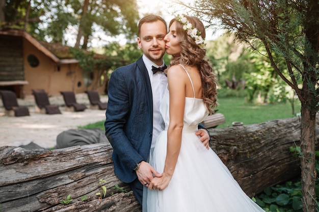 Novia y el novio en el día de la boda caminando al aire libre en la naturaleza de verano