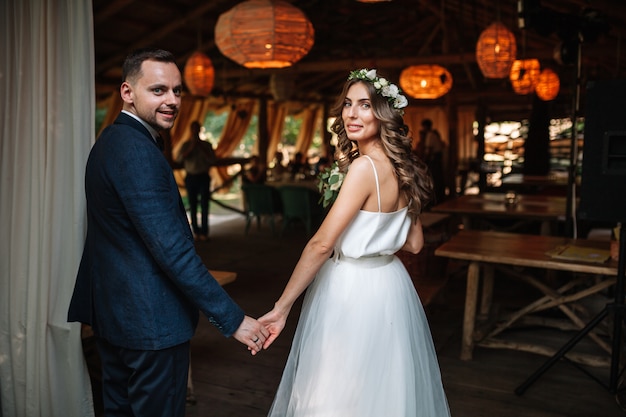 Novia y el novio en el día de la boda caminando al aire libre en la naturaleza de verano