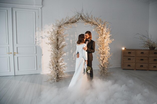 novia y novio en el día de su boda cerca del arco festivo