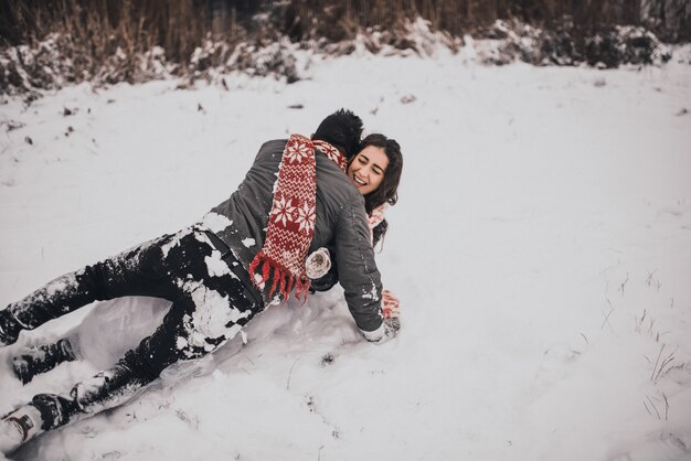 La novia y el novio enamorados pareja en bufanda tejida y guantes de invierno