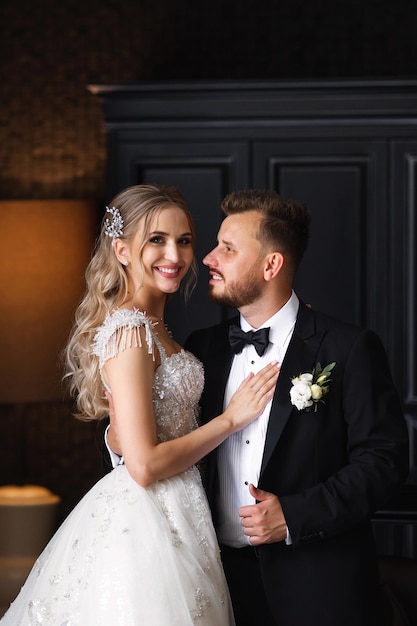 Una novia y un novio están parados frente a una puerta negra.