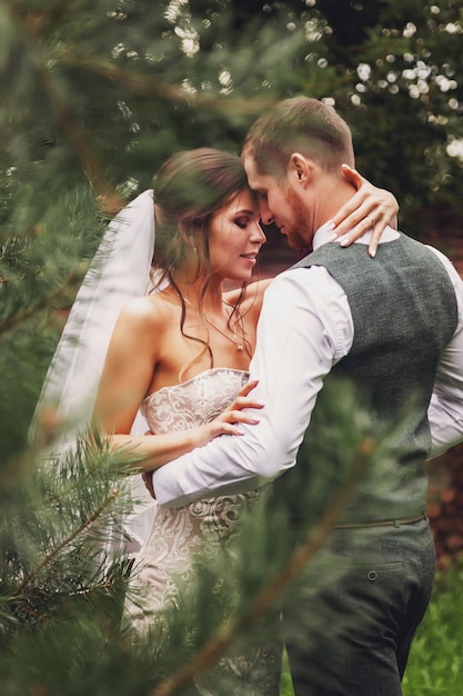 La novia y el novio estilo irlandés en el día de la boda caminando al aire libre en casa de pueblo. Pareja nupcial feliz recién casada mujer y hombre caminan en un parque verde o boscoso. Concepto de día del matrimonio y casados.