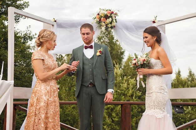 La novia y el novio en el evento de estilo irlandés de bodas en el país al aire libre Registrador con ceremonia de boda oficial junto a la pareja nupcial