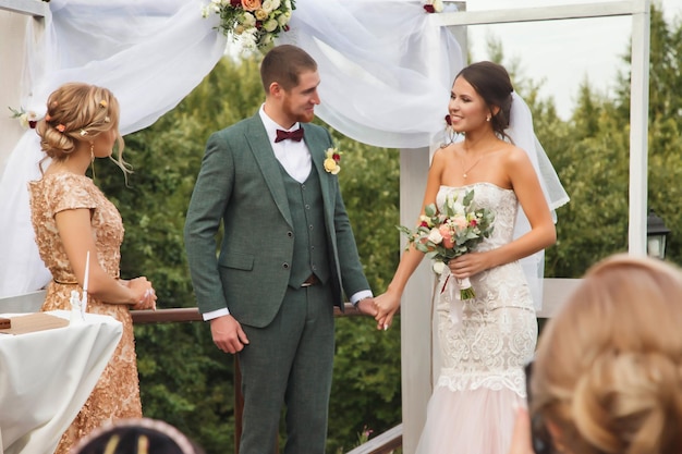 La novia y el novio en un evento de estilo irlandés casado en el país al aire libre Pareja nupcial con ceremonia de boda oficial junto al registrador