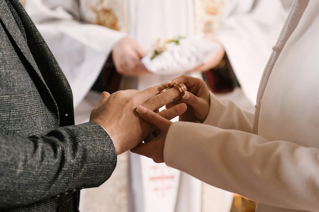 La novia y el novio intercambian anillos en la iglesia el sacramento de la boda