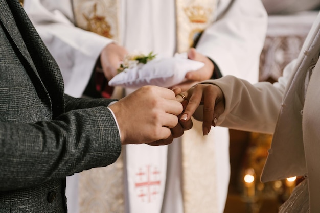 La novia y el novio intercambian anillos en la iglesia el sacramento de la boda