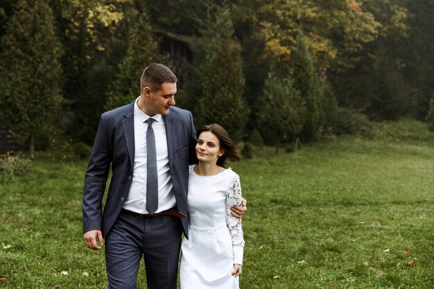 La novia y el novio en otoño al aire libre