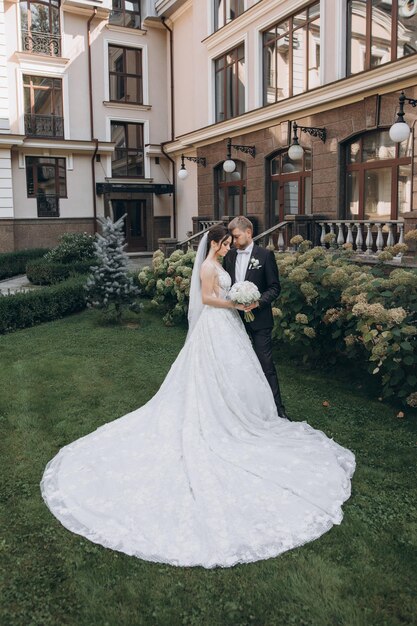 la novia y el novio se paran en el jardín