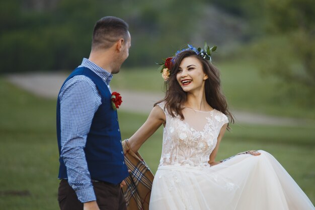 La novia y el novio en un parque kissing.couple novios novios en una boda en la naturaleza bosque verde se besan retrato fotográfico.