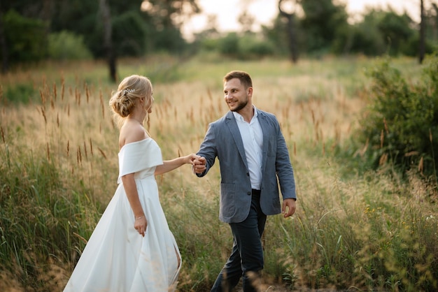 La novia y el novio en un paseo por el bosque