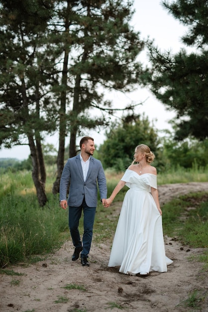 La novia y el novio en un paseo por el bosque