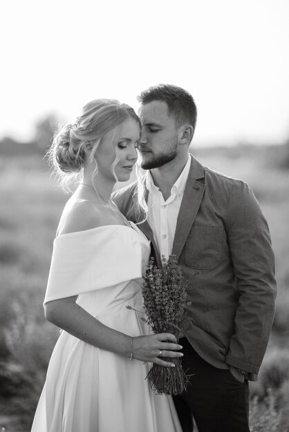 La novia y el novio en un paseo por el campo de lavanda