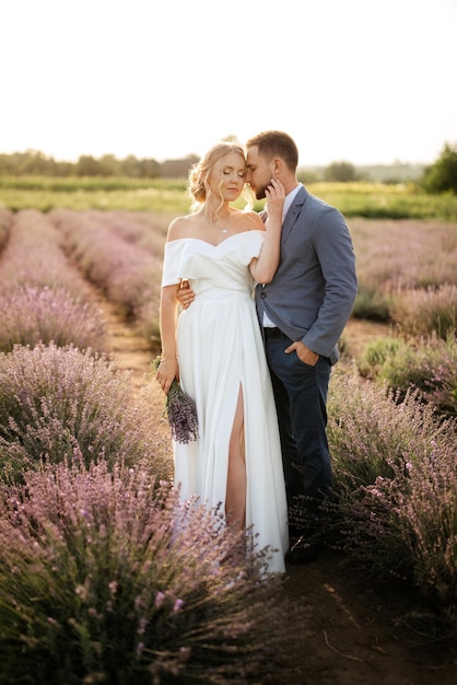 La novia y el novio en un paseo por el campo de lavanda