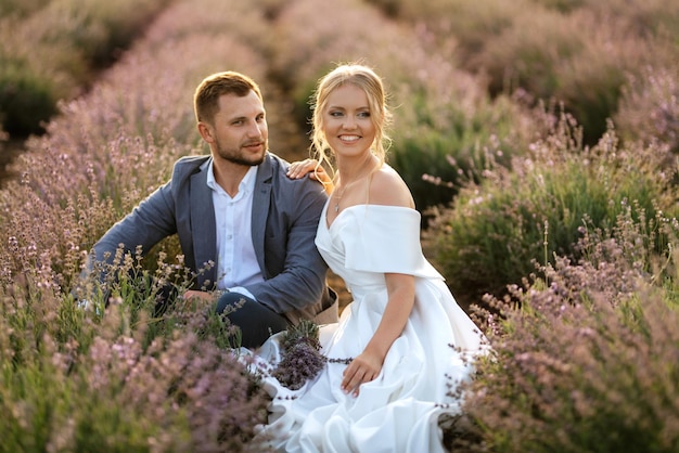 La novia y el novio en un paseo por el campo de lavanda