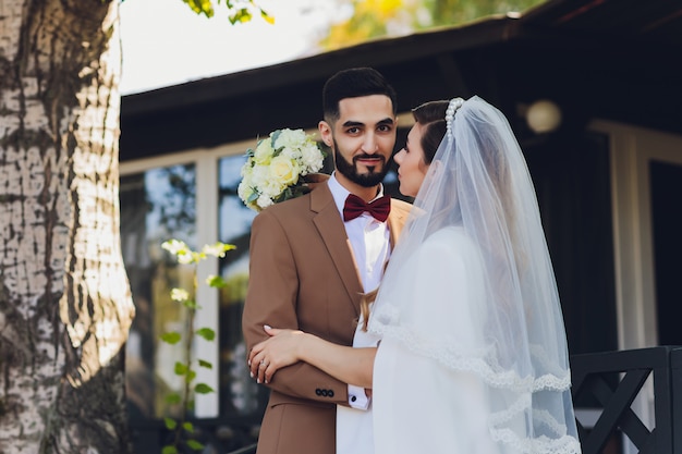 Novia y el novio en el porche de una antigua casa de campo.