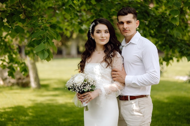 Una novia y un novio posan para una foto en un parque.