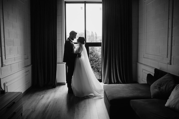 Una novia y un novio posan en una habitación de hotel.