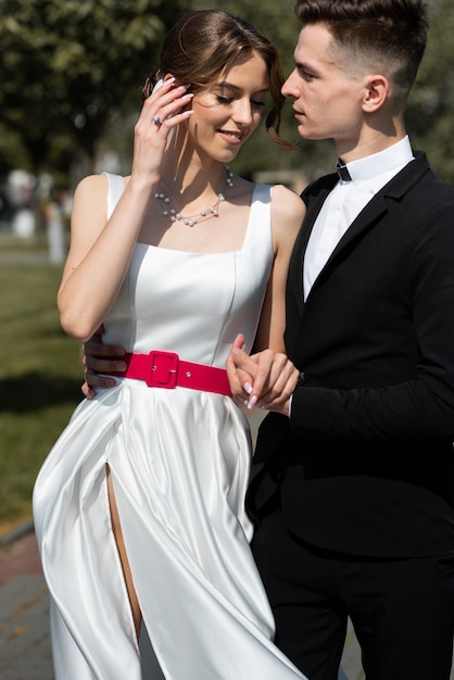 La novia y el novio posando en campo verde