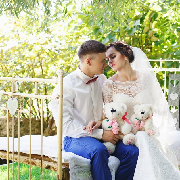 La novia y el novio posando en un jardín.