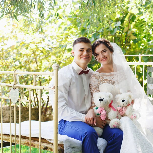 La novia y el novio posando en un jardín.