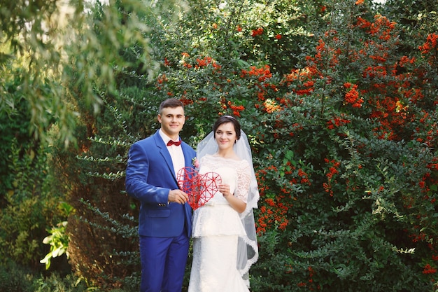 La novia y el novio posando en un jardín.