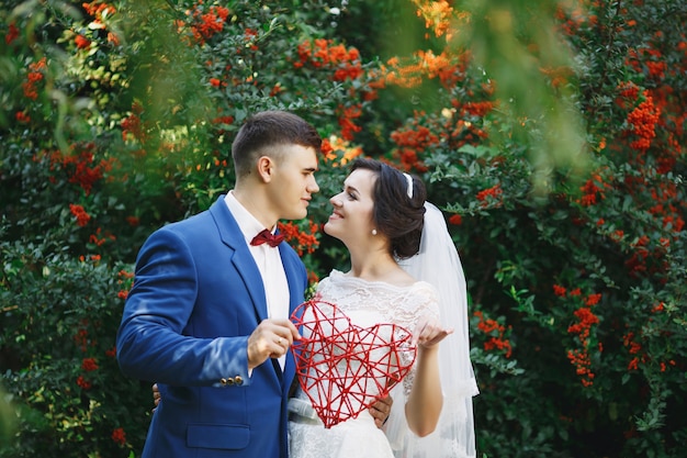 La novia y el novio posando en un jardín.