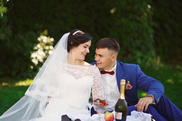 La novia y el novio posando en un jardín.